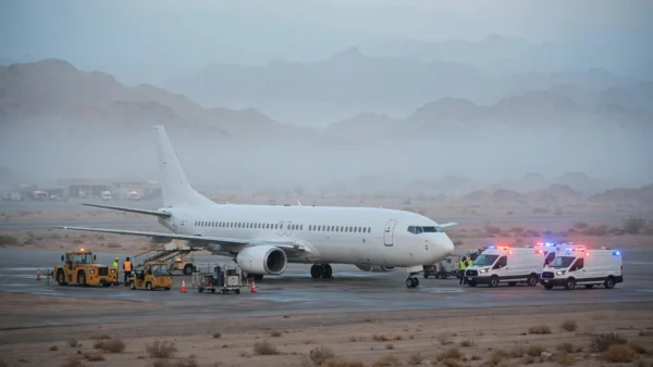 White passenger aircraft on the tarmac at Tabuk airport in Saudi Arabia surrounded by emergency vehicles after its emergency diversion.