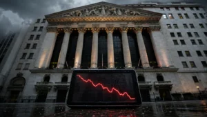 New York Stock Exchange under a dark sky with a screen showing a falling red stock chart, symbolising Monday's market selloff