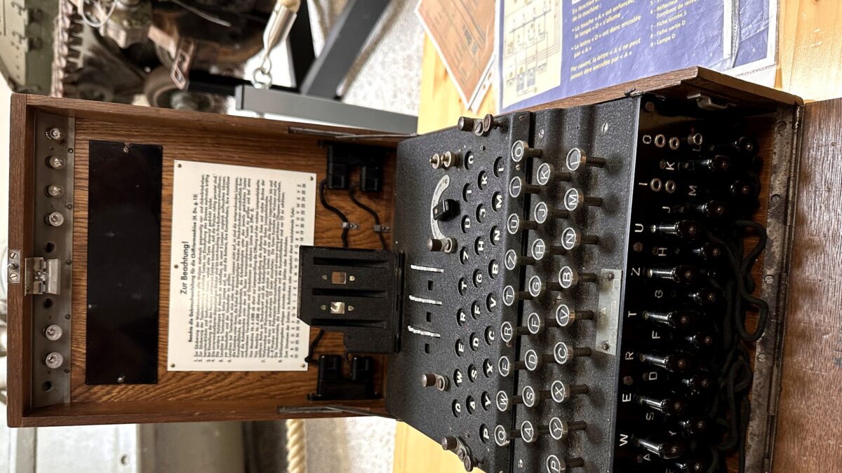 An Enigma cipher machine on museum display — the code machine of history that mirrors Claude's solution of the NSA's 25-year cryptographic mystery.
