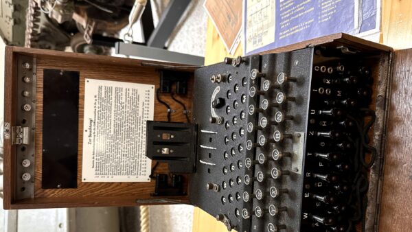 An Enigma cipher machine on museum display — the code machine of history that mirrors Claude's solution of the NSA's 25-year cryptographic mystery.