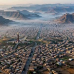 Aerial view of Mekelle, the capital of Ethiopia's Tigray region, nestled among highland mountains at dawn.