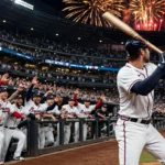Atlanta Braves players celebrate in the dugout at a packed night-time Truist Park after winning the NL Wild Card Game 3 over the Philadelphia Phillies