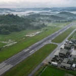 Aerial view of the new China-Laos joint military airfield at Ban Keun, Laos, with runway and hangars amid tropical fields