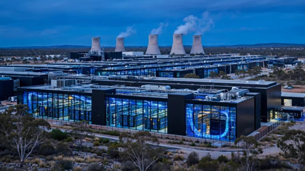 Photorealistic editorial image of a vast Australian AI data centre with illuminated server halls and glowing fibre-optic cables at dusk, symbolising the withdrawn Firmus IPO