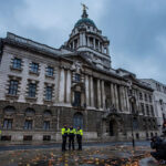 The Old Bailey in London at dusk, with police officers, a police van and press photographers gathered outside the historic court building.