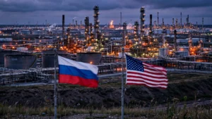 Oil refinery complex at dusk with Russian and American flags flying in the foreground