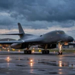 A US B-1 strategic bomber taxiing on a military airbase runway at dusk