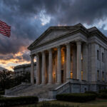 A federal courthouse in Washington D.C. at dusk with the American flag flying, symbolising the court ruling against the Justice Department's voter-roll audit.
