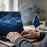 A person typing on a laptop with blue digital watermark waves rising above the screen and a European Union flag on the desk, representing OpenAI's invisible text watermarking for ChatGPT in the EU