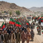 Crowd of PTI supporters with party flags on a highway in Lakki Marwat during the long march toward Islamabad