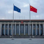 The European Union and Chinese national flags flying side by side in front of Beijing's Great Hall of the People