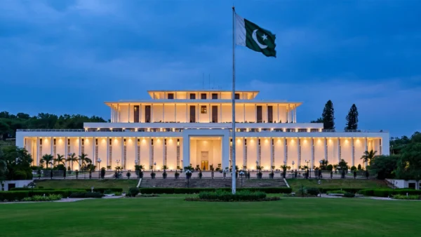 Aiwan-e-Sadr, Pakistan's Presidency in Islamabad, illuminated at dusk with the Pakistani flag flying — the venue of Thursday's Shehbaz-Zardari meeting.