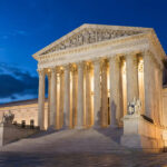 The U.S. Supreme Court building in Washington DC lit up at dusk