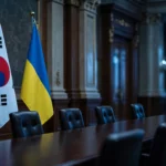 South Korean and Ukrainian flags standing side by side in a government hall, reflecting the diplomatic row over the transfer of two North Korean soldiers